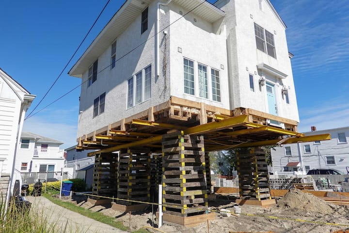 A team of professionals using specialized equipment to raise a house in Johnson City, preparing it for elevation and renovation